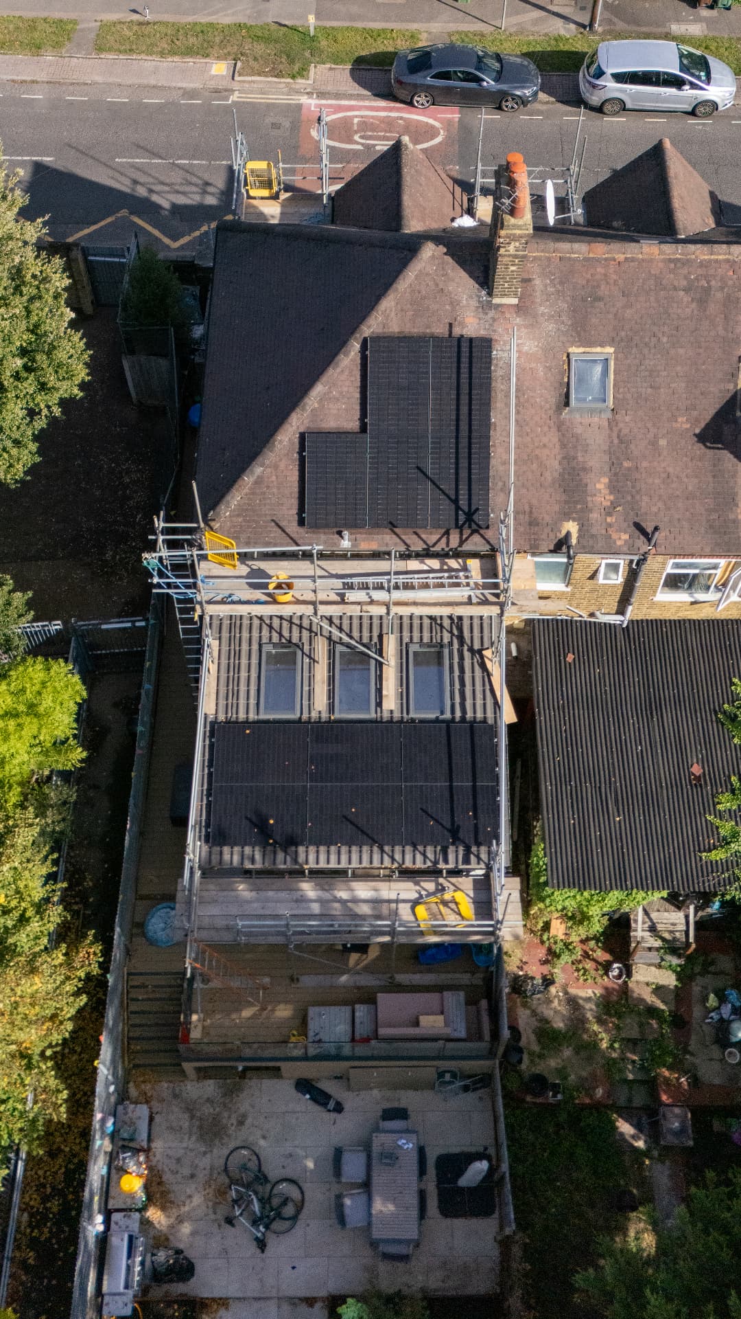 Aerial view of solar panels being installed on a Walthamstow home, with scaffolding in place